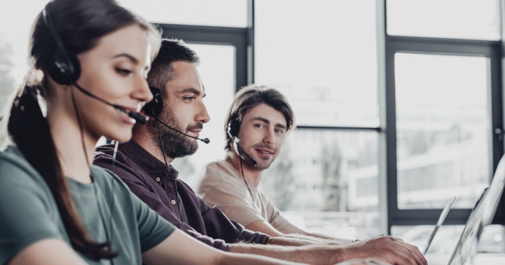 Telefonos kérdezők fejhallgatóval egy irodában – AI telefonos lekérdezés közvélemény-kutató cégeknek